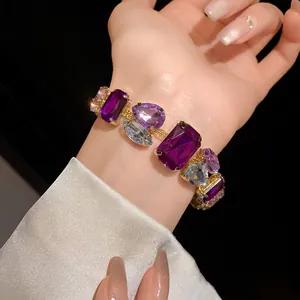 Close-up detail of a luxury purple and clear crystal gemstone bracelet on a hand model's wrist