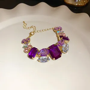 Detail shot of a luxury bracelet with purple and pink gemstones on a white plate
