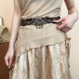 Detailed shot of Bohemian woven rope waist chain with wooden beads and turquoise pendant