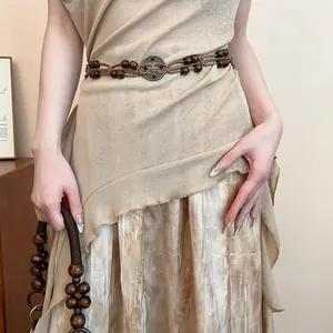Close-up of bohemian braided hemp rope waist chain with wooden beads and vintage buckle