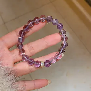 Dettaglio ravvicinato di un bracciale in cristallo ametista viola con distanziatore oro