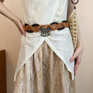 Close-up of a Bohemian style woven rope waist belt with wooden beads and vintage metal buckle