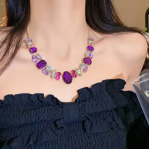 Detail view of a luxury statement necklace with purple crystals on a model's neck
