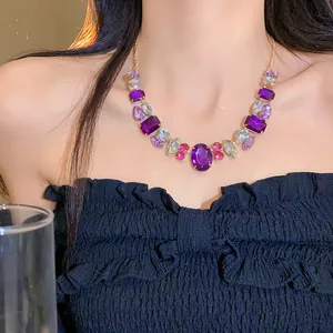 Macro detail view of a luxury gold-tone statement necklace with purple and pink crystals