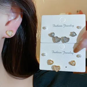 Detail showing elegant 18k gold plated zircon heart and pearl stud earring set...
