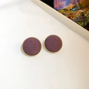 Gros plan de boucles d'oreilles rétro en tissu violet avec bord doré élégant