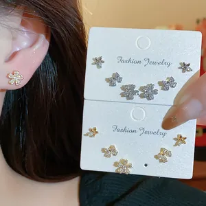 Close-up of sparkling zircon stud earrings set featuring flower and bow designs