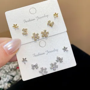 Close-up detail of zircon-encrusted bow and flower stud earring sets on display cards