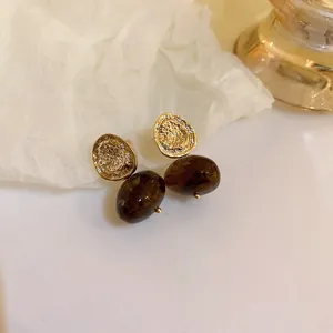 Vintage style silver needle earrings with coffee brown beads and gold coin accents.