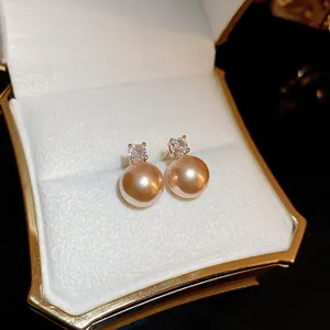 Détail de boucles d'oreilles perles café avec cristal dans son écrin