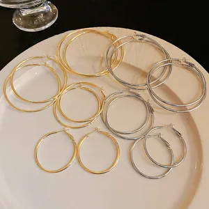 Detailed view of simple gold and silver metal hoop earrings set in various sizes on a plate