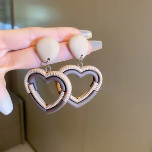 Gros plan de boucles d'oreilles cœur texturées marron rétro.