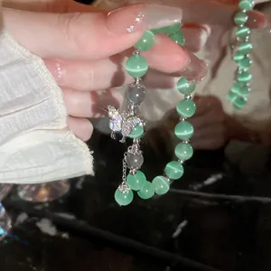 Elegant green cat eye beaded bracelet with a sparkling crystal butterfly charm for women
