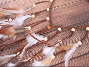Detailed macro view showing the soft feathers and wooden beads of a Bohemian style headband accessory