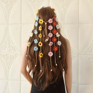 Bohemian daisy floral headband with long woven tassels and beads shown on long brown hair.