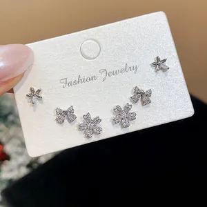 Sparkling zircon stud earrings set featuring bow, flower, and star designs in silver finish.