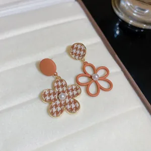 Détail de boucles d'oreilles vintage en pied-de-poule marron avec perles de culture