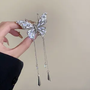 Detailed view of a silver butterfly hair claw clip with rhinestones and long tassels