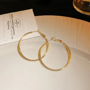 Detailed view of polished gold round hoop earrings with a secure clasp closure.