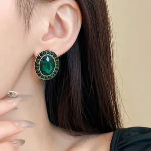 Detailansicht der vintage smaragdgrünen ovalen Strass-Ohrstecker am Ohr getragen