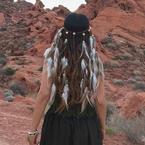 Bohemian feather headband with beads and long tassels worn by a woman in a desert canyon.