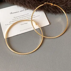 Detailed view of large gold hoop earrings with minimalist stainless steel design.