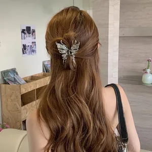 Elegant silver butterfly hair claw clip shown styling long brown hair in a chic half-updo