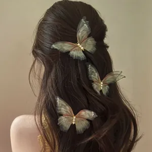 Close-up of translucent butterfly hair clips with pearls on dark wavy hair