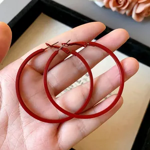 Close-up of vibrant red matte oversized hoop earrings with stainless steel pins