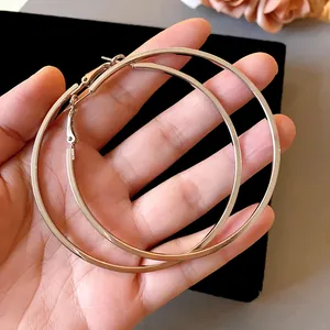 Detailed view of oversized silver minimalist hoop earrings featuring flat metal surface