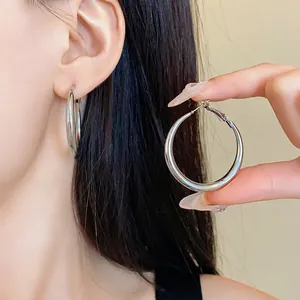 Orecchini a cerchio rotondi geometrici minimalisti con ago in argento su modella