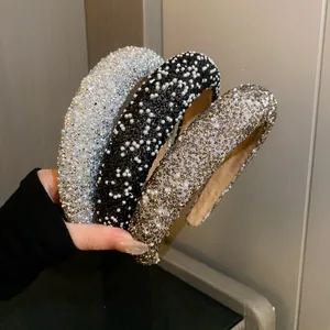 Detailed view of high-end luxury rhinestone and pearl embellished wide padded headbands for women