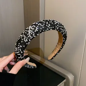 Close-up of elegant padded headband with black rhinestones and white pearls
