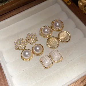 Detail view of vintage pearl and geometric earring set in a jewelry box