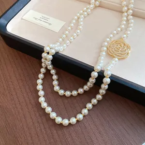 Detailed macro shot of vintage pearl necklace featuring gold hollow rose with crystals