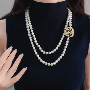 Detail view of elegant double-strand pearl necklace with hollow zircon rose pendant on model