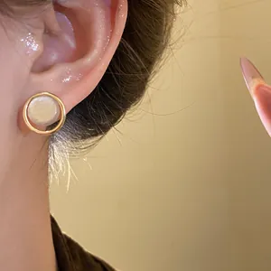 Detail view of vintage French style geometric pearl stud earrings with gold-tone finish