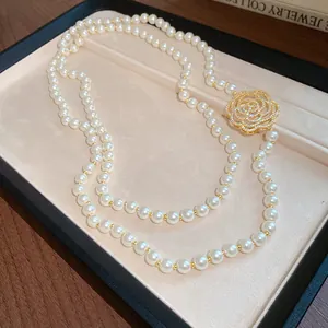 Close-up detail of an elegant hollow-out zircon flower pendant on a classic luxury pearl necklace