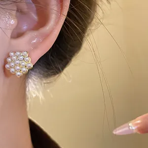 Elegant close-up view of vintage geometric cluster pearl stud earrings worn on ear