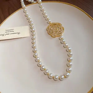 Detailed close-up showing the hollow zircon flower and lustrous pearls of the necklace
