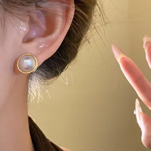 Close-up detail of a vintage French style pearl stud earring with gold beaded border