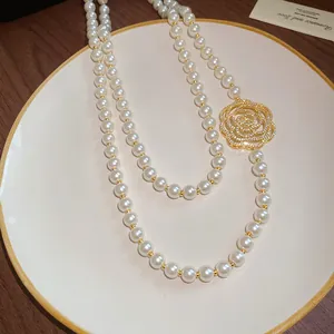 Detailed view of an elegant long pearl necklace featuring a hollow zircon flower pendant