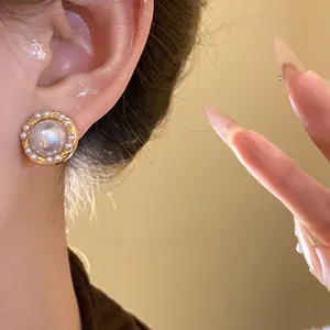 Close-up of elegant French vintage pearl stud earrings worn by a model