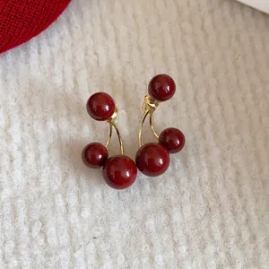 Elegantes pendientes de cereza roja retro con acabado brillante sobre punto blanco