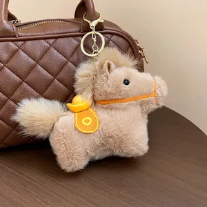 Creative cute plush horse keychain with gold ingot charm used as a stylish bag decoration.