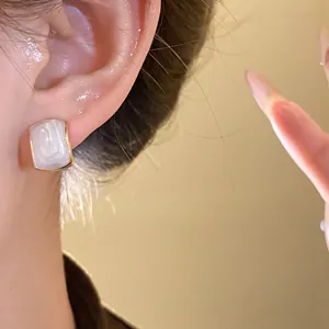 Detailed close-up view of French retro geometric pearl stud earrings with a golden border