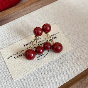 Primer plano de pendientes de cereza roja Ankora retro sobre una etiqueta vintage