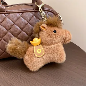 Detailed close-up of a cute brown plush pony keychain featuring a lucky gold ingot