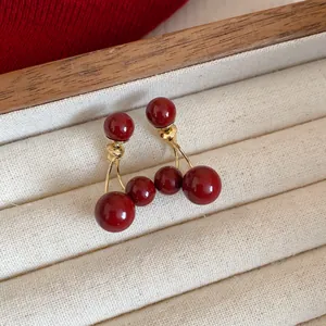 Vista detallada de pendientes de cereza rojo Ancora sobre una bandeja de joyas