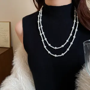 Detailed close-up showing the elegant double-layered pearl long necklace on a black outfit